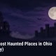 Fostoria News: Illustration of a generic Victorian mansion and an old stone prison silhouette under a full moon at night, with headline: Top 10 Most Haunted Places in Ohio (Allegedly)